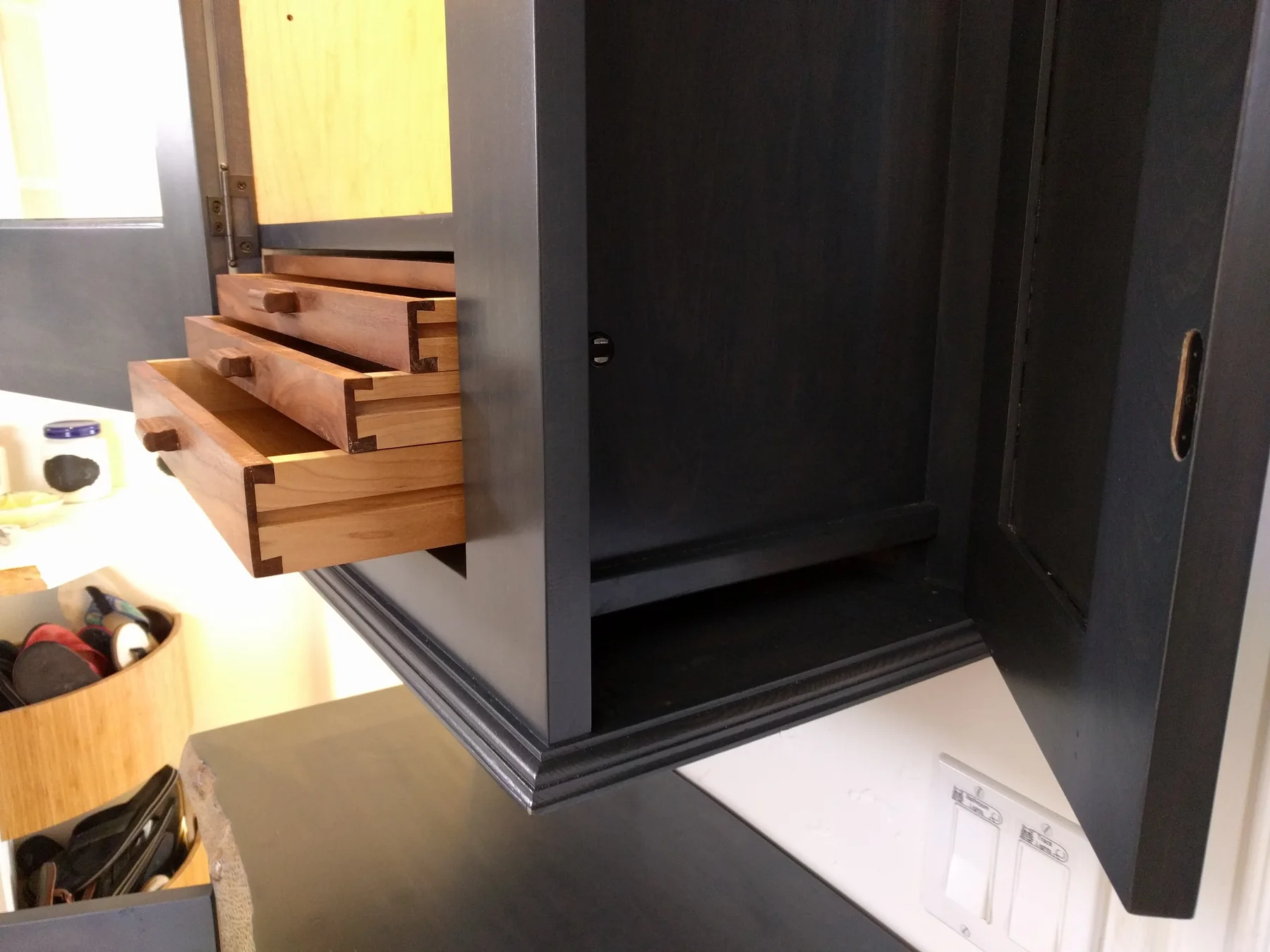 Open full-height storage inside the dark-finished built-in