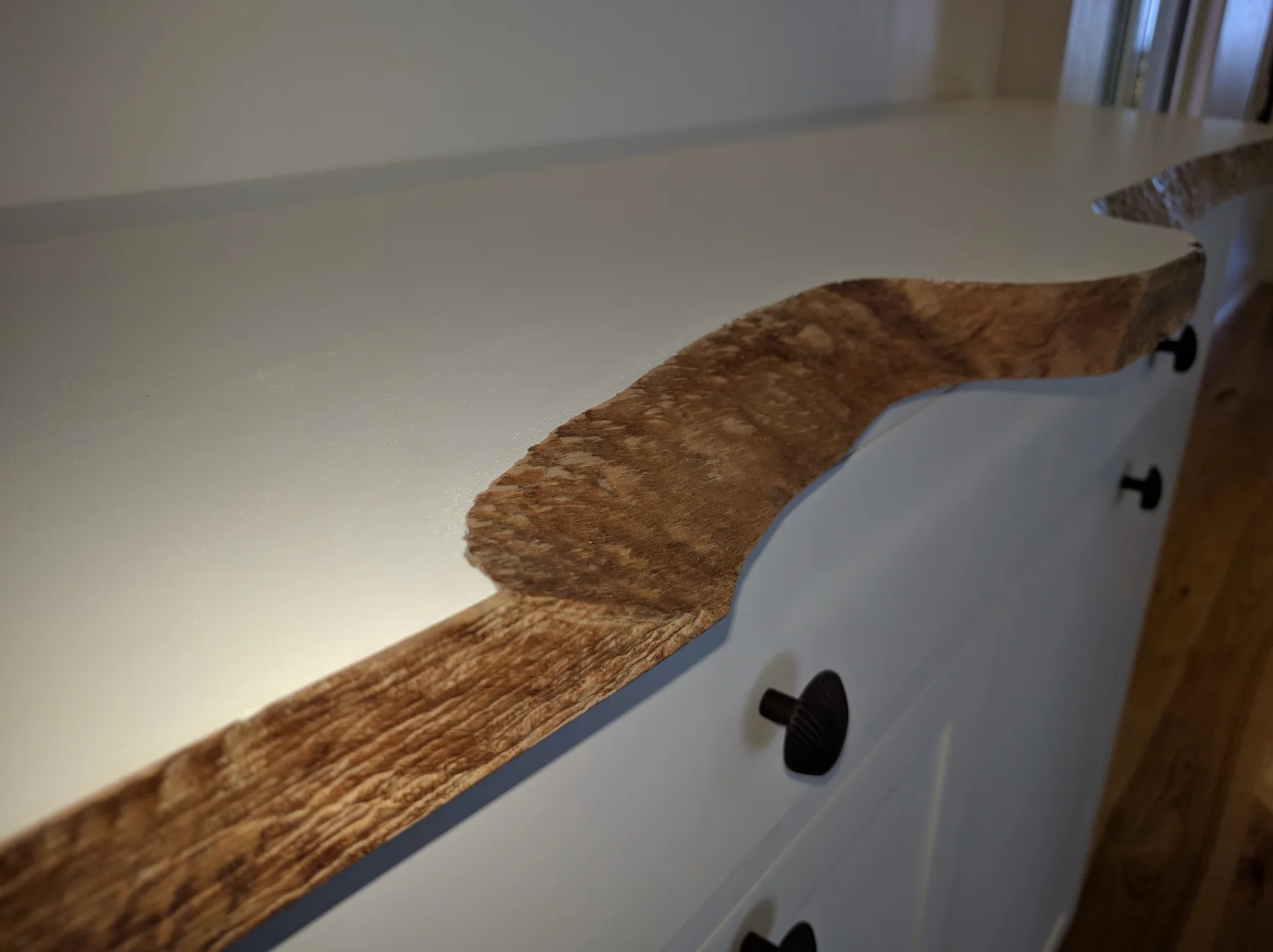 Natural-edge detail along a painted custom storage counter