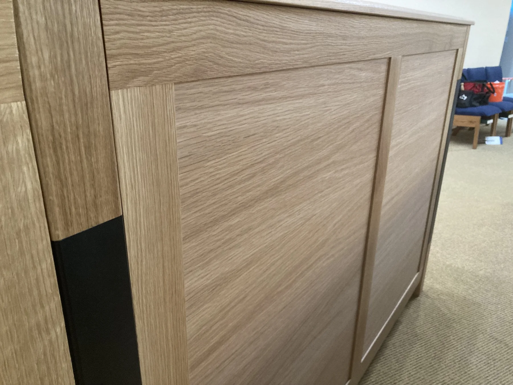 Framed White Oak panels meeting a dark vertical inlay